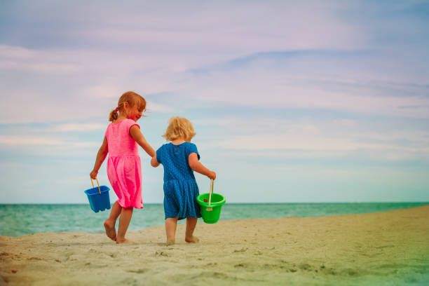 istock little girls walking on beach 1003915566