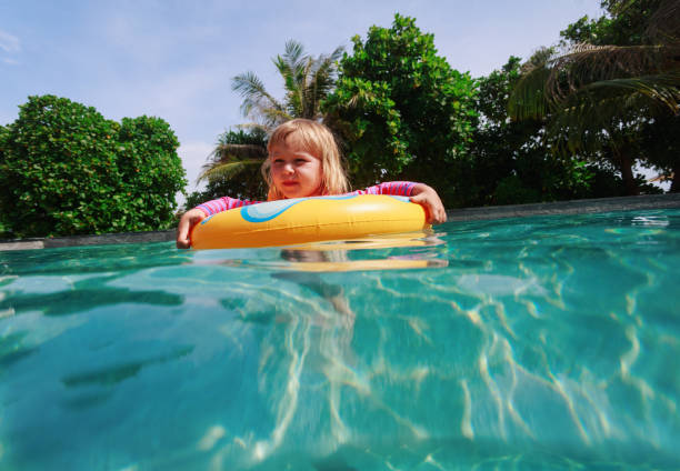 istock little girl in floating ring having fun on beach 1003915674