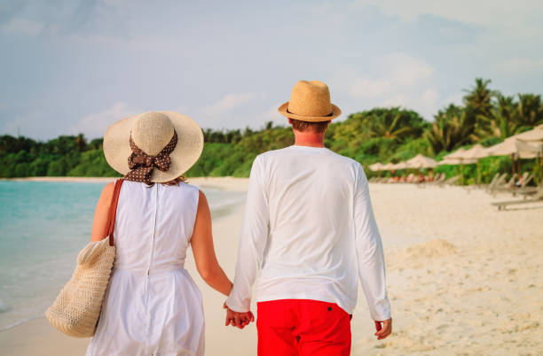 istock happy loving couple walk on beach 1003918288