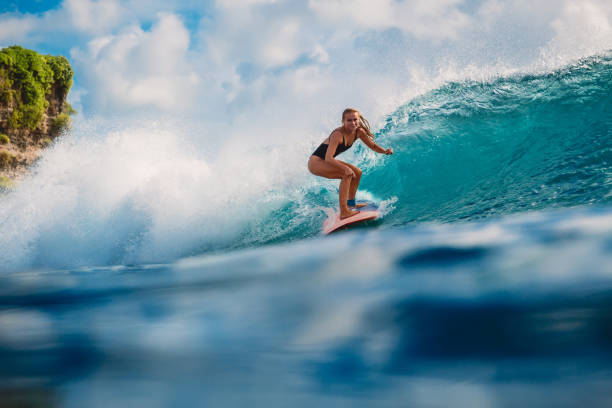 istock Surf woman on surfboard during surfing. Surfer and ocean wave 1003943200