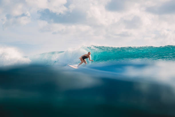 istock Surfer girl on wave in ocean 1003943282