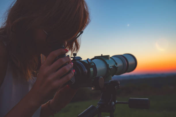 istock Girl looking at lunar eclipse through a telescope. My astronomy work. 1003951744