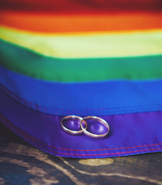 istock Colorful rainbow flag with two wedding rings 1003954060