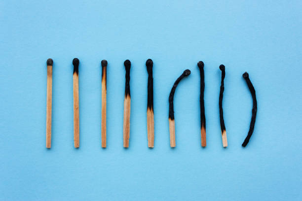 Burned matches in a row on a blue background. Burned matches in a row on a blue background. The concept of depression, extinction, illness, burnout, aging. View from above, flat mental burnout photos stock pictures, royalty-free photos & images