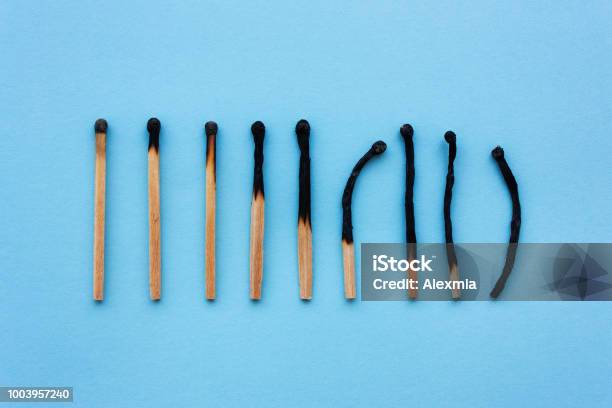 Burned Matches In A Row On A Blue Background Stock Photo - Download Image Now - Mental Burnout, Match - Lighting Equipment, Burnt