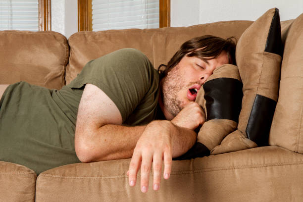 Man taking a quick nap on the couch stock photo