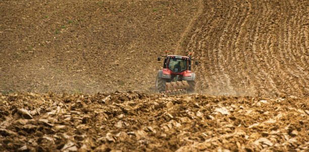 istock Farmer on tractor plow field, France 1003973888