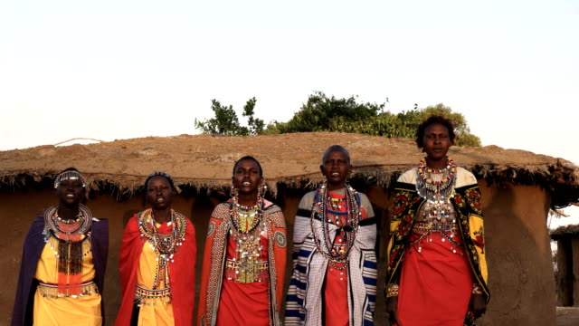 five maasai women singing and dancing in a village near maasai mara