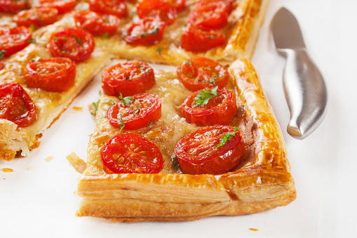 Tomato tart, puff pastry topped with mustard, cheese and cherry toamtoes.