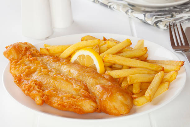 Fish and Chips Battered fish with chips in a light, bright setting. deep fried photos stock pictures, royalty-free photos & images