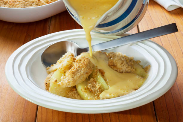 crumble de manzana y natillas verter - crema de natillas fotografías e imágenes de stock