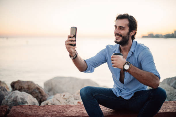 istock Man sitting by the sea 1003982668