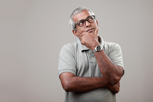 Middle aged man of Indian origin with a thinking face