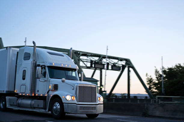 istock Big rig powerful semi truck running on evening twilight road 1003988946