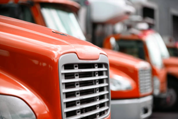 Middle sized rigs semi trucks standing in row in warehouse dock for loading cargo Comfortable and compact middle sized rigs semi trucks standing in row in warehouse dock for loading cargo for local shipping and deliveries commercial cargo to business and stores in the city limit car hauling stock pictures, royalty-free photos & images
