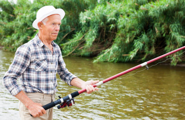 istock Mature man angling at riverside 1003990510