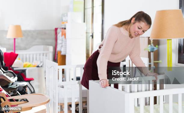Woman Buyer Choosing Wooden Crib Stock Photo - Download Image Now - Crib, Store, Buying