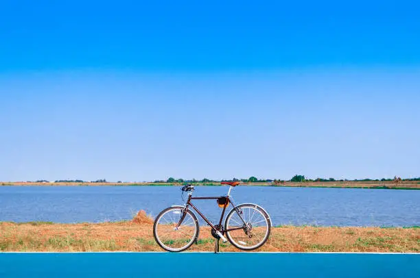 A Bike by the lake with clear blue summer sky.