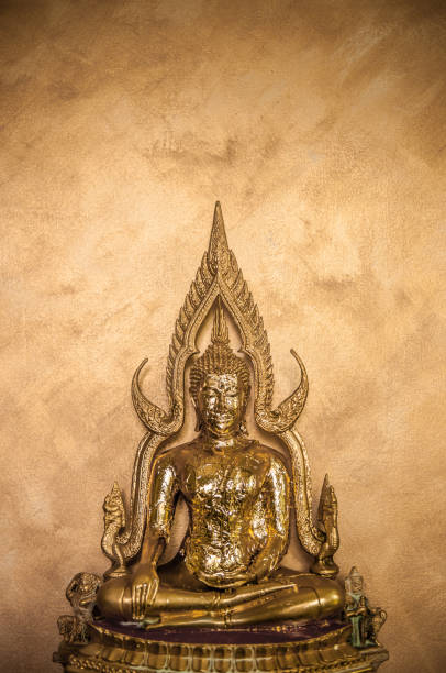 istock Gold leaves on Buddha Sculpture on gold wall background 1003994564