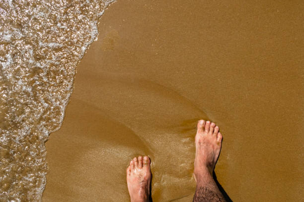istock walk on the sand and sea wave 1004007318