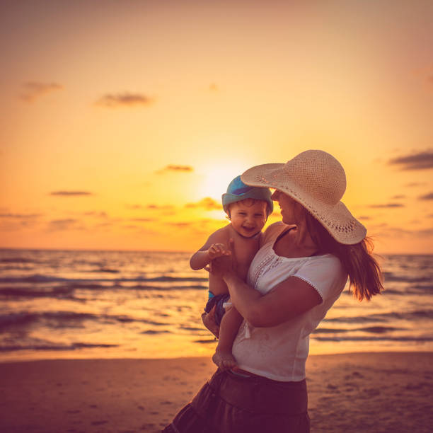 istock Happy mother and son on the beach in sunset 1004013586