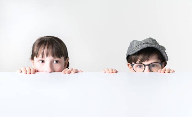 Cute child playing together in parent's bed, little girl looking at camera