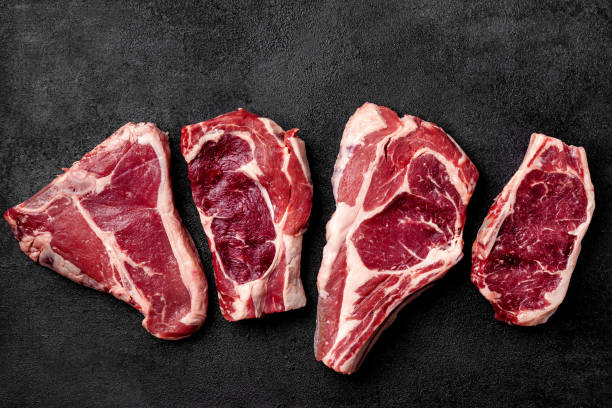 istock Meat raw steak lies on a black background. side view, copy space, top view 1004022658