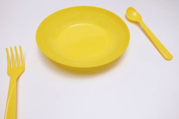 istock Set of a yellow plate, spoon and fork 1004026896
