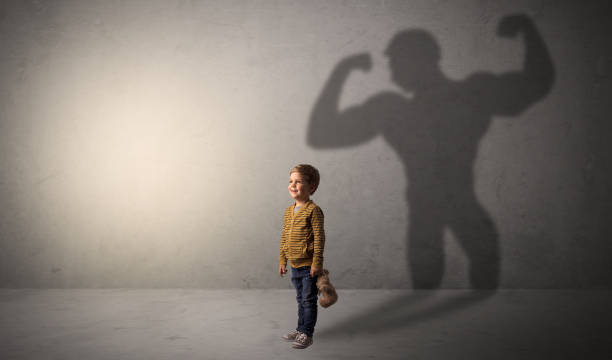 istock Muscleman shadow behind waggish little boy 1004029782