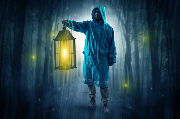 istock Mysterious man coming from a path in the forest with glowing lantern concept 1004033812
