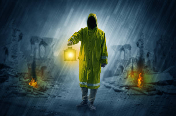 istock Man with a glowing lantern at a catastrophe scene 1004033894