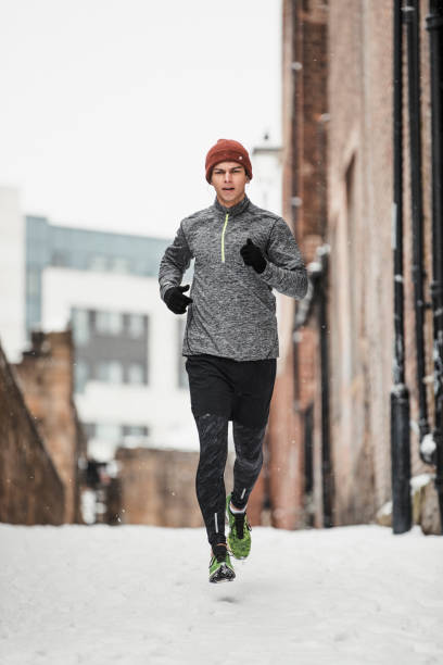 istock Young Man Running In The Snow 1004034656