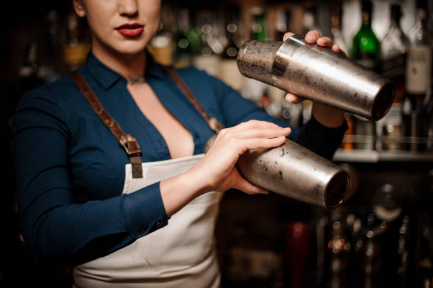 istock Beautiful sexy barmaid making cocktail in shaker 1004036252