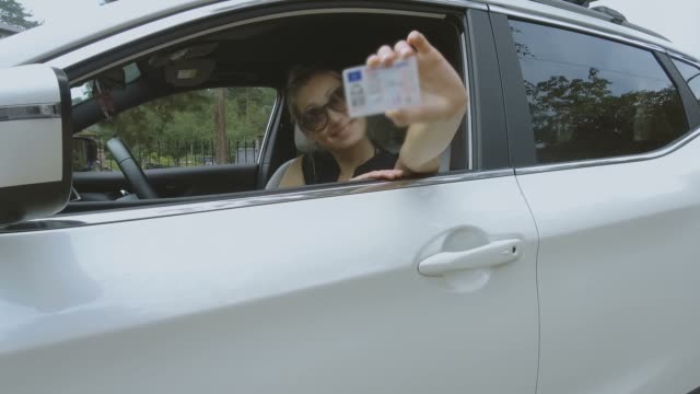 young happy woman showing her new driver license