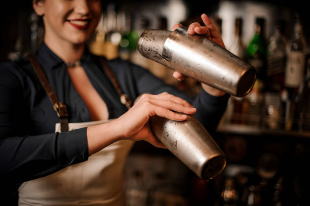 istock Beautiful smiling barmaid making cocktail in shaker 1004039482