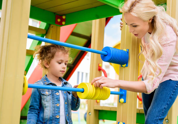 istock mother teaching to count little daughter on abacus at playground 1004039898