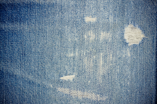 Stock photo showing close-up view of patches of denim, in various colours, stitched together in a swatch to assist customers in the selection of their preferred pair of jeans.