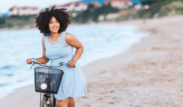istock African woman enjoying biking on beach 1004048156