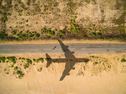 Aerial view airplane shadow and man on sunny road