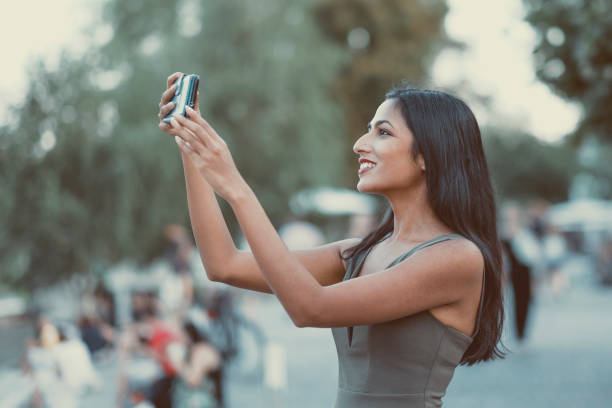 istock Young woman taking a picture with her mobile phone 1004049248