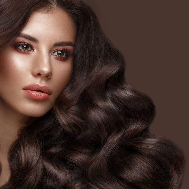 istock Beautiful brunette model: curls, classic makeup and full lips. The beauty face. 1004049566