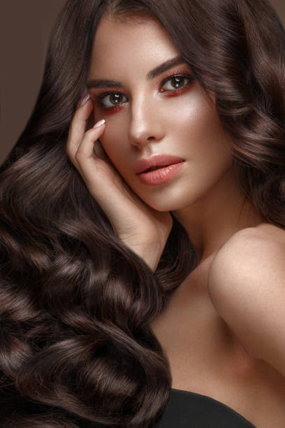 istock Beautiful brunette model: curls, classic makeup and full lips. The beauty face. 1004049638