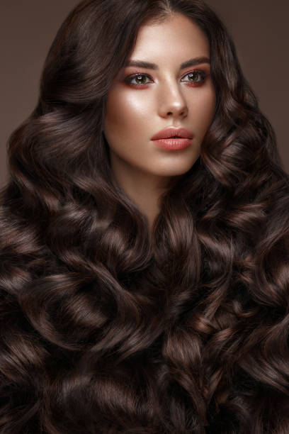 istock Beautiful brunette model: curls, classic makeup and full lips. The beauty face. 1004049674