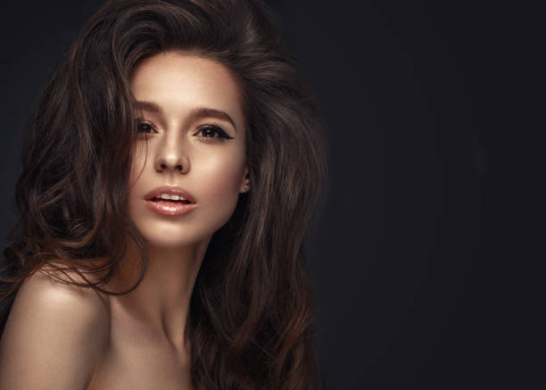istock Beautiful brunette model : volume curls, classic makeup and sexy lips. The beauty face. 1004049676