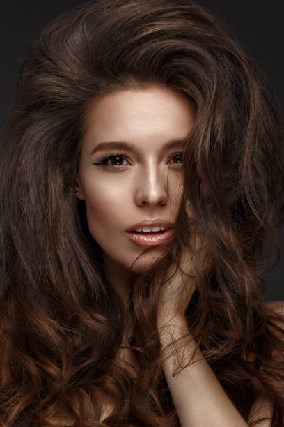 istock Beautiful brunette model : volume curls, classic makeup and sexy lips. The beauty face. 1004049714
