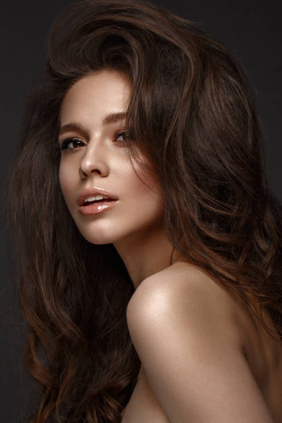 istock Beautiful brunette model : volume curls, classic makeup and sexy lips. The beauty face. 1004049718