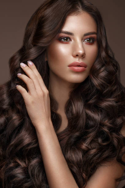 istock Beautiful brunette model: curls, classic makeup and full lips. The beauty face. 1004049726