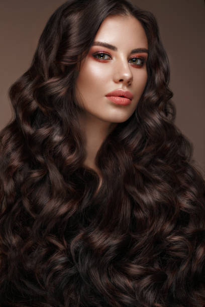 istock Beautiful brunette model: curls, classic makeup and full lips. The beauty face. 1004049812