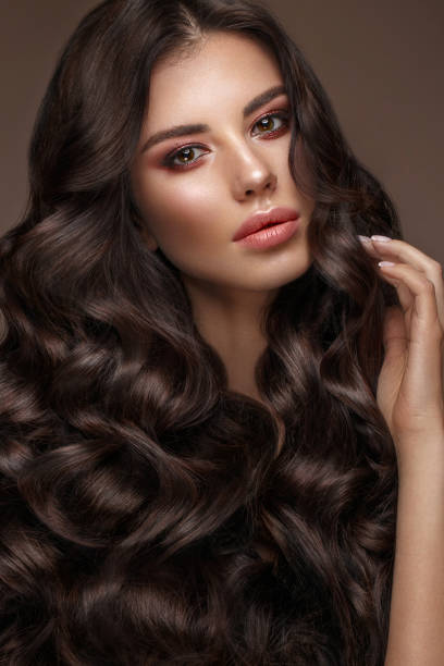 istock Beautiful brunette model: curls, classic makeup and full lips. The beauty face. 1004049848