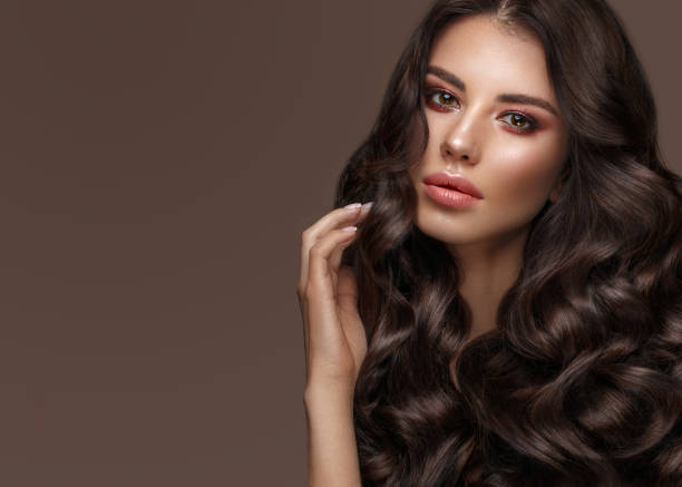 istock Beautiful brunette model: curls, classic makeup and full lips. The beauty face. 1004049850